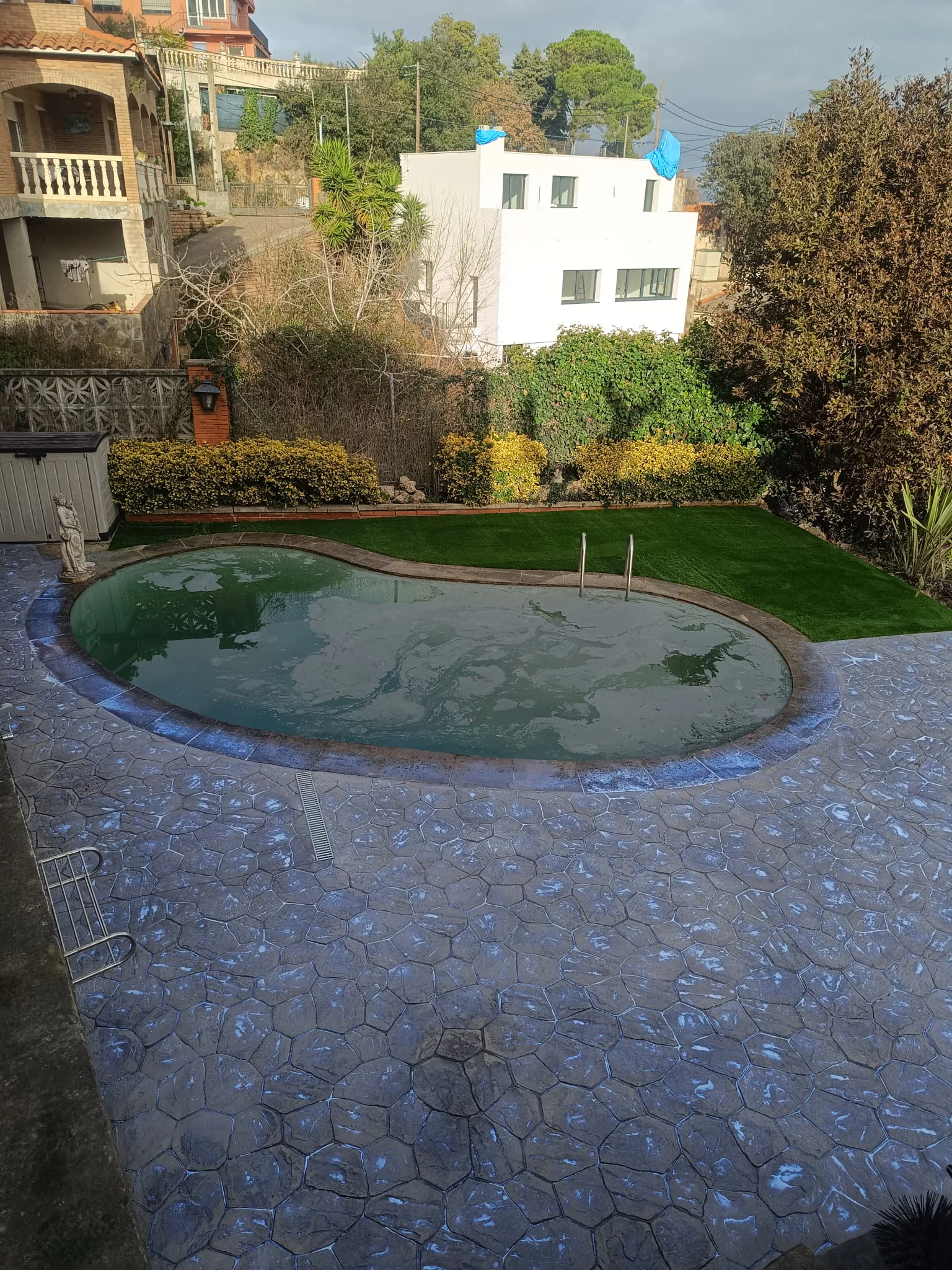 Césped artificial y pavimento impreso alrededor de piscina